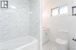 Full bathroom with light marble finish floors, vanity, and tub / shower combination - 