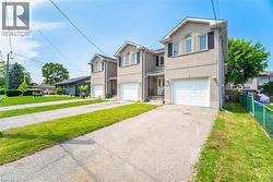 Traditional-style home featuring driveway, brick siding, an attached garage, and a residential view - 
