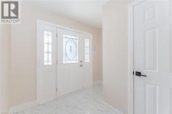 Foyer entrance featuring light marble finish flooring and baseboards - 
