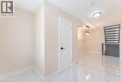 Hall featuring light marble finish flooring and a chandelier - 