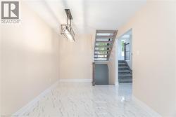 Entryway with light marble finish floors, stairway, and a chandelier - 