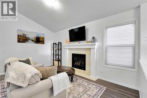 65 Sunset Heights, Cochrane, AB - Indoor Photo Showing Living Room With Fireplace