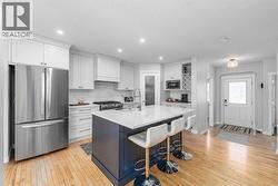 Quartz countertops, stainless steel appliances, a 5-burner gas stove, oversized island with extra storage, and a corner pantry - 