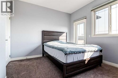 4th bderoom with balcony - 14 Marquis Heights Se, Calgary, AB - Indoor Photo Showing Bedroom