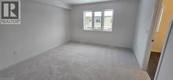 Empty room with light colored carpet and baseboards - 