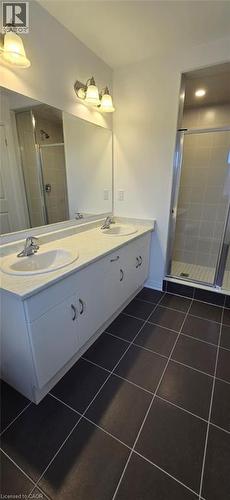 Bathroom with double vanity, a stall shower, and dark tile patterned floors - 925 Douro Street, Stratford, ON - Indoor Photo Showing Bathroom