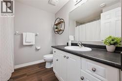 Bathroom featuring dark wood-style floors, curtained shower, vanity, and a textured ceiling - 