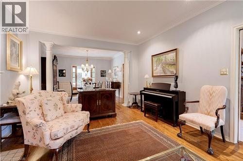 Living area with decorative columns, crown molding, light wood-style floors, a chandelier, and recessed lighting - 166 Maple Grove Drive, Oakville, ON - Indoor Photo Showing Living Room