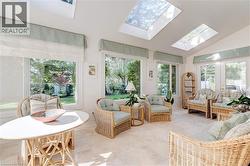 Sunroom / solarium with lofted ceiling, a skylight, healthy amount of natural light, and tile patterned floors - 