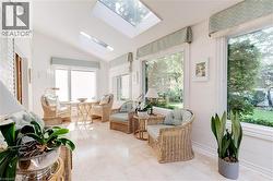 Sunroom / solarium featuring a skylight, vaulted ceiling, and tile patterned flooring - 