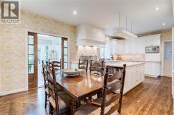 Dining area with wallpapered walls, healthy amount of natural light, french doors, dark wood-type flooring, and recessed lighting - 