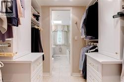 Walk in closet with light tile patterned floors - 