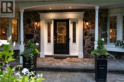 Doorway to property featuring stone siding and covered porch - 166 Maple Grove Drive, Oakville, ON - Outdoor With Deck Patio Veranda