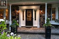 Doorway to property featuring stone siding and covered porch - 