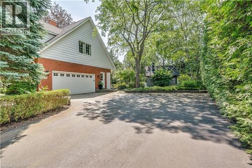 View of home's exterior featuring brick siding, asphalt driveway, a chimney, and a garage - 166 Maple Grove Drive, Oakville, ON - Outdoor