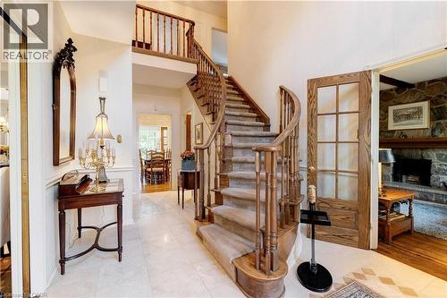 Stairway featuring a stone fireplace, a towering ceiling, and tile patterned flooring - 166 Maple Grove Drive, Oakville, ON - Indoor Photo Showing Other Room