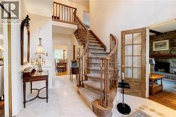 Stairway featuring a stone fireplace, a towering ceiling, and tile patterned flooring - 