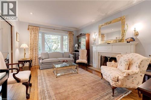 Living area featuring ornamental molding, hardwood / wood-style flooring, and a lit fireplace - 166 Maple Grove Drive, Oakville, ON - Indoor Photo Showing Living Room With Fireplace
