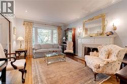 Living area featuring ornamental molding, hardwood / wood-style flooring, and a lit fireplace - 