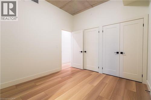 Unfurnished bedroom featuring two closets and light wood finished floors - 24 Augusta Street Unit# 305, Hamilton, ON - Indoor Photo Showing Other Room