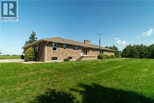 Back of house with a yard, brick siding, and a chimney - 6828 Third Line, Chatham, ON 
