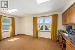 Home office with light carpet, healthy amount of natural light, and a textured ceiling - 