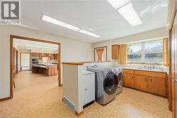 Laundry area with light flooring, independent washer and dryer, and cabinet space - 