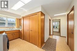 Kitchen featuring brown cabinets, light floors, washer / clothes dryer, and light countertops - 