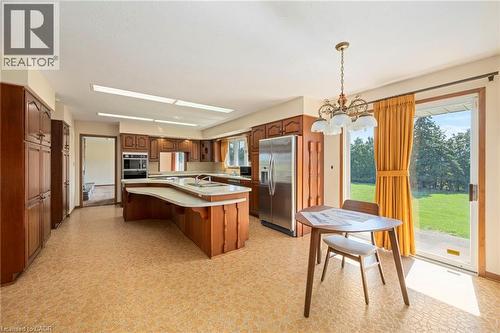 Kitchen with light flooring, stainless steel appliances, an island with sink, and a kitchen breakfast bar - 6828 Third Line, Chatham, ON - Indoor Photo Showing Other Room