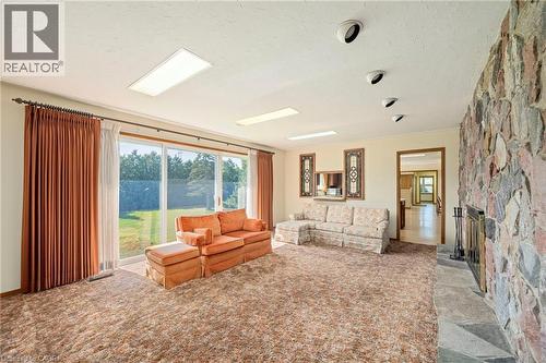 Living room with a fireplace and a textured ceiling - 6828 Third Line, Chatham, ON - Indoor