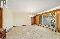 Spare room featuring a chandelier and light carpet - 