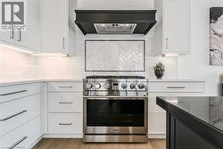 Kitchen with stainless Gas stove & modern exhaust hood - 