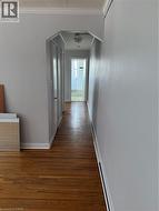 Corridor featuring wood finished floors and ornamental molding - 