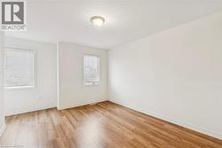 Spare room featuring light wood-style floors and baseboards - 