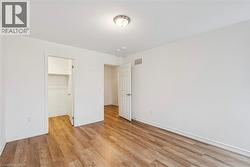 Unfurnished bedroom with a walk in closet and light wood-style floors - 