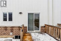 Doorway to property featuring a wooden deck and board and batten siding - 