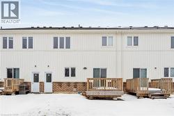 Snow covered back of property with a deck - 