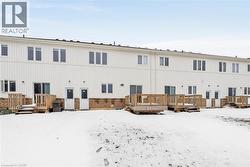 Snow covered property featuring a wooden deck, brick siding, and board and batten siding - 