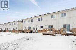 Snow covered rear of property featuring a deck and board and batten siding - 