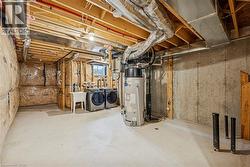 Unfinished below grade area with water heater and separate washer and dryer - 