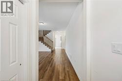 Corridor featuring dark wood-style floors and stairway - 