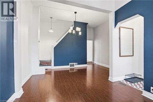 Unfurnished living room featuring dark wood-style flooring and a chandelier - 313 Mary Street, Hamilton, ON - Indoor Photo Showing Other Room