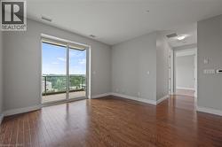 Unfurnished room featuring dark wood-style flooring and baseboards - 