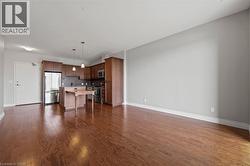 Unfurnished living room with baseboards and dark wood-style flooring - 