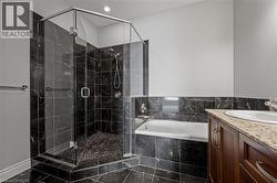 Full bathroom featuring a bath, vanity, a shower stall, and marble finish flooring - 