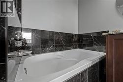 Full bathroom featuring a garden tub, vanity, and a wall mounted air conditioner - 