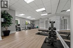 Workout area with wood finished floors and a drop ceiling - 