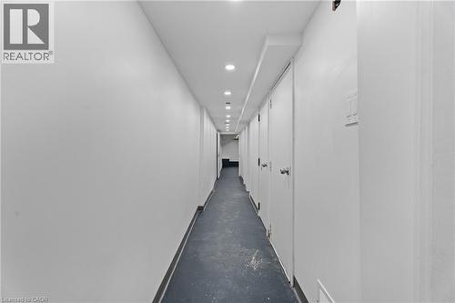 Hallway with finished concrete floors and recessed lighting - 93 John Street S, Hamilton, ON 