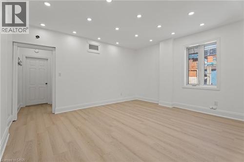 Empty room with light wood finished floors and recessed lighting - 93 John Street S, Hamilton, ON 