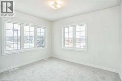 Carpeted empty room featuring baseboards and visible vents - 